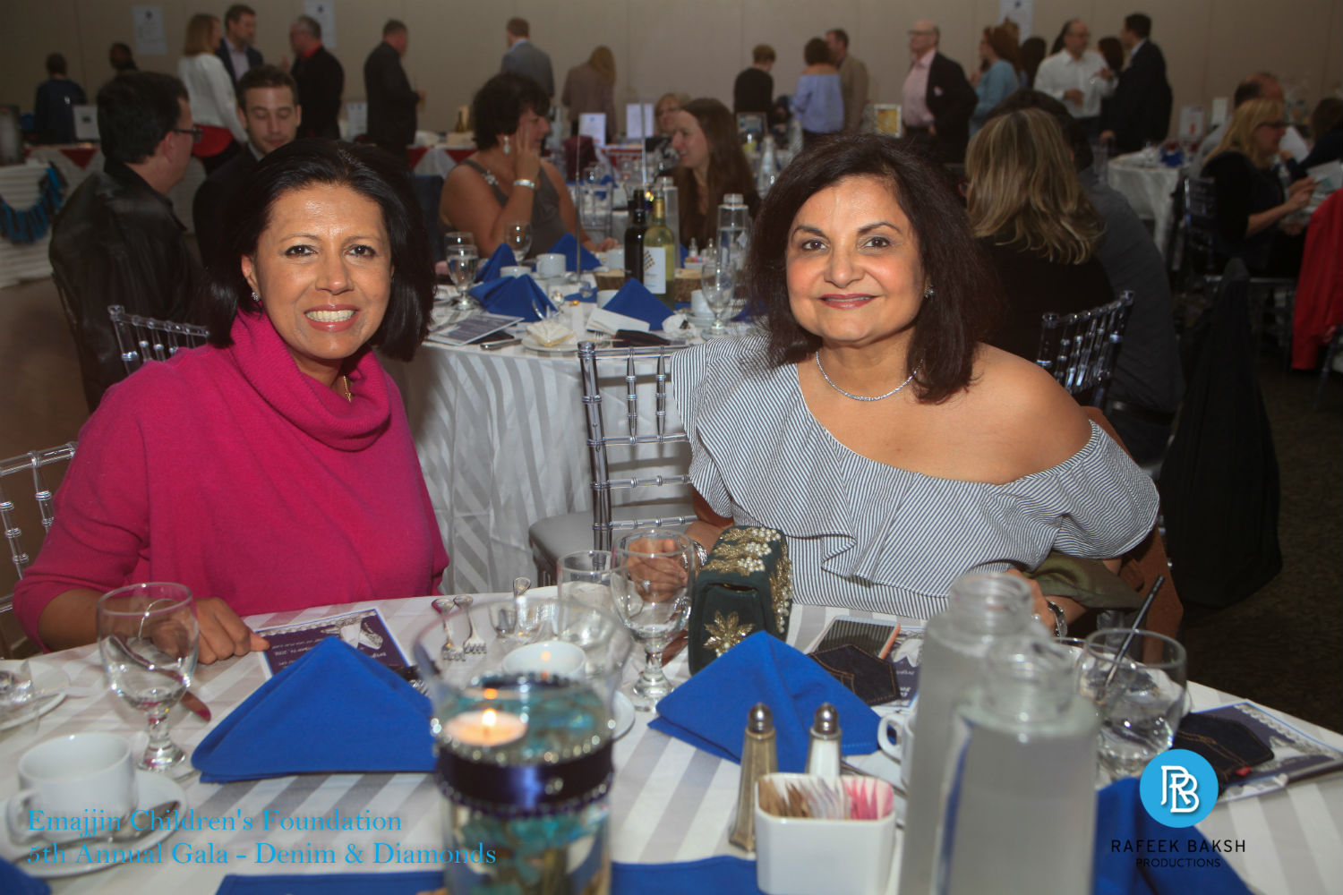 Two gala attendees sitting at a table and smiling at the 2018 Denim and Diamonds gala