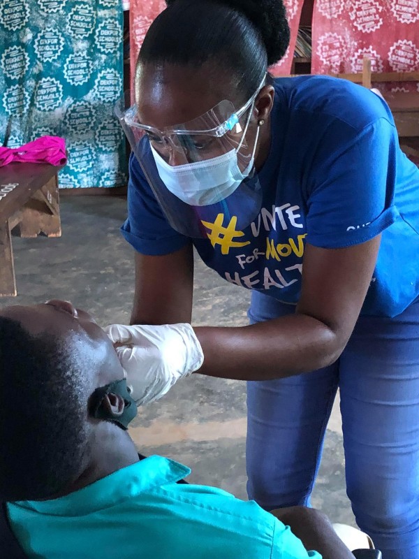 A dentist treating a patient in Dekpor during Health Week 2021 funded by Emajjin