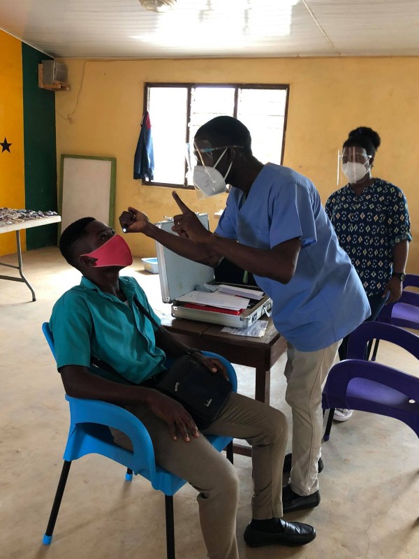 A student receiving an eye exam during Dekpor Health Week 2021 — their first vision test