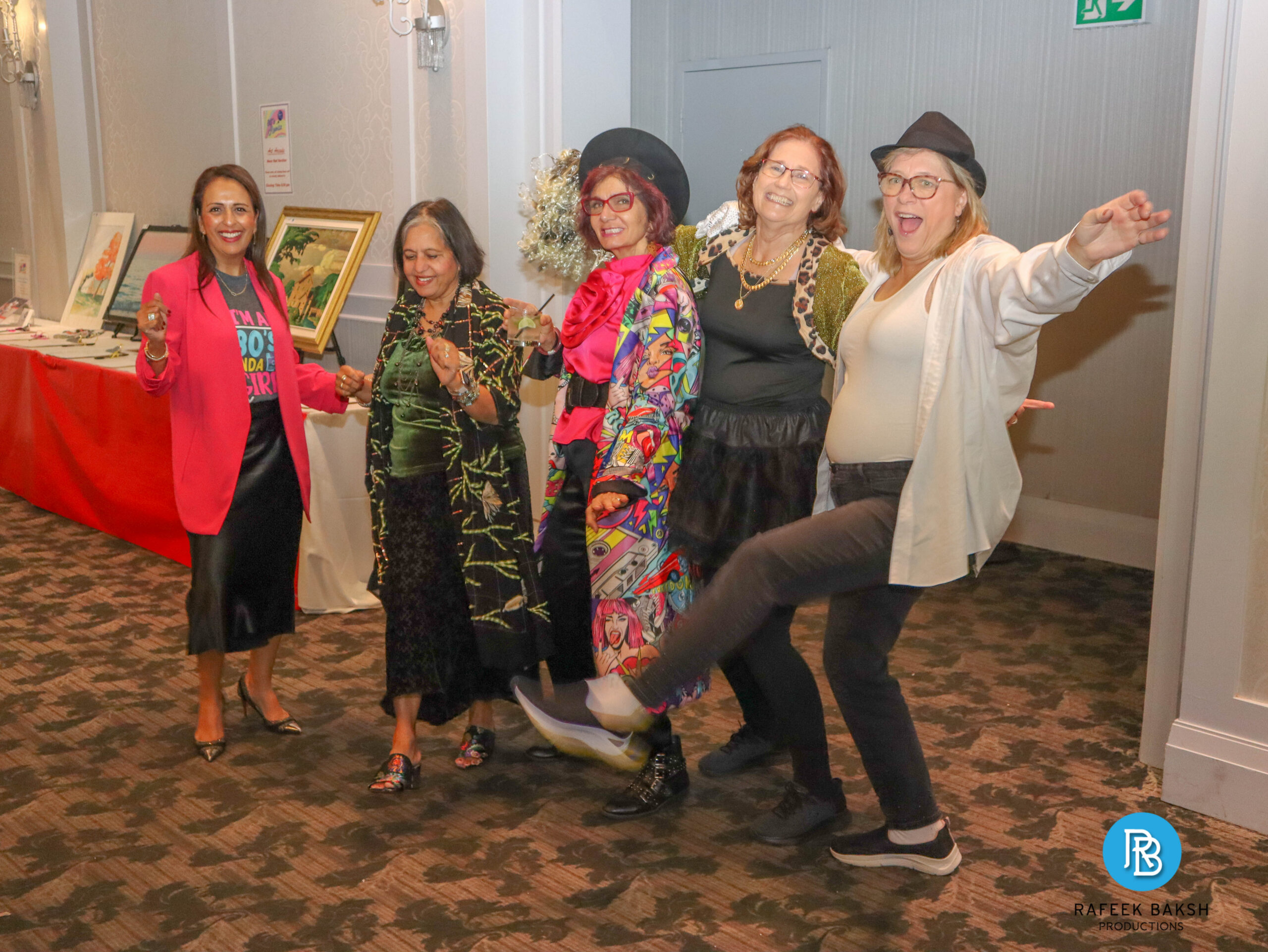 Group of ladies wearing 80s themed clothing dancing and laughing at the 2025 80s Remix Gala
