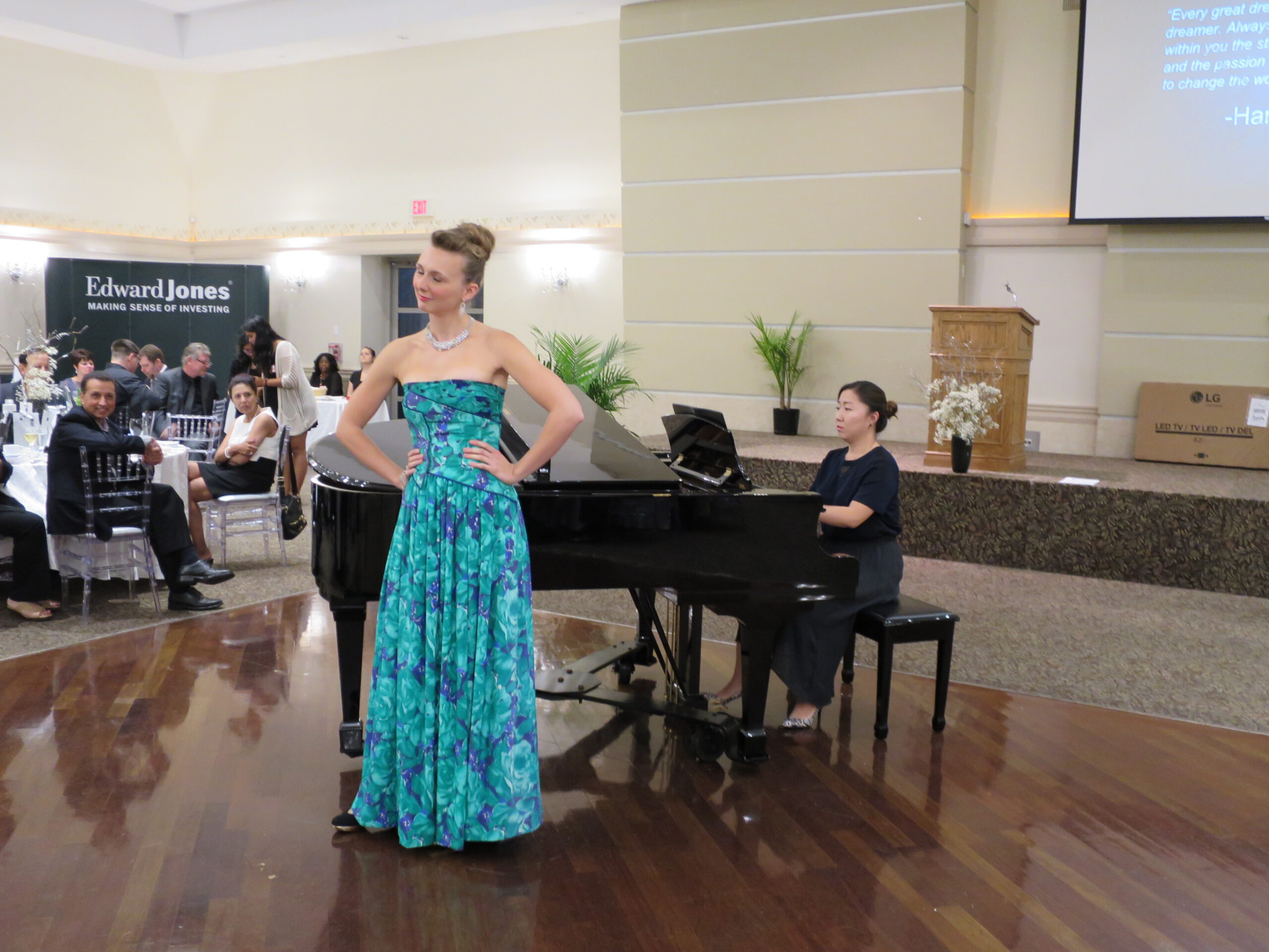 A performer standing in front of the piano at the 2015 Emajjin Reach for the Stars gala