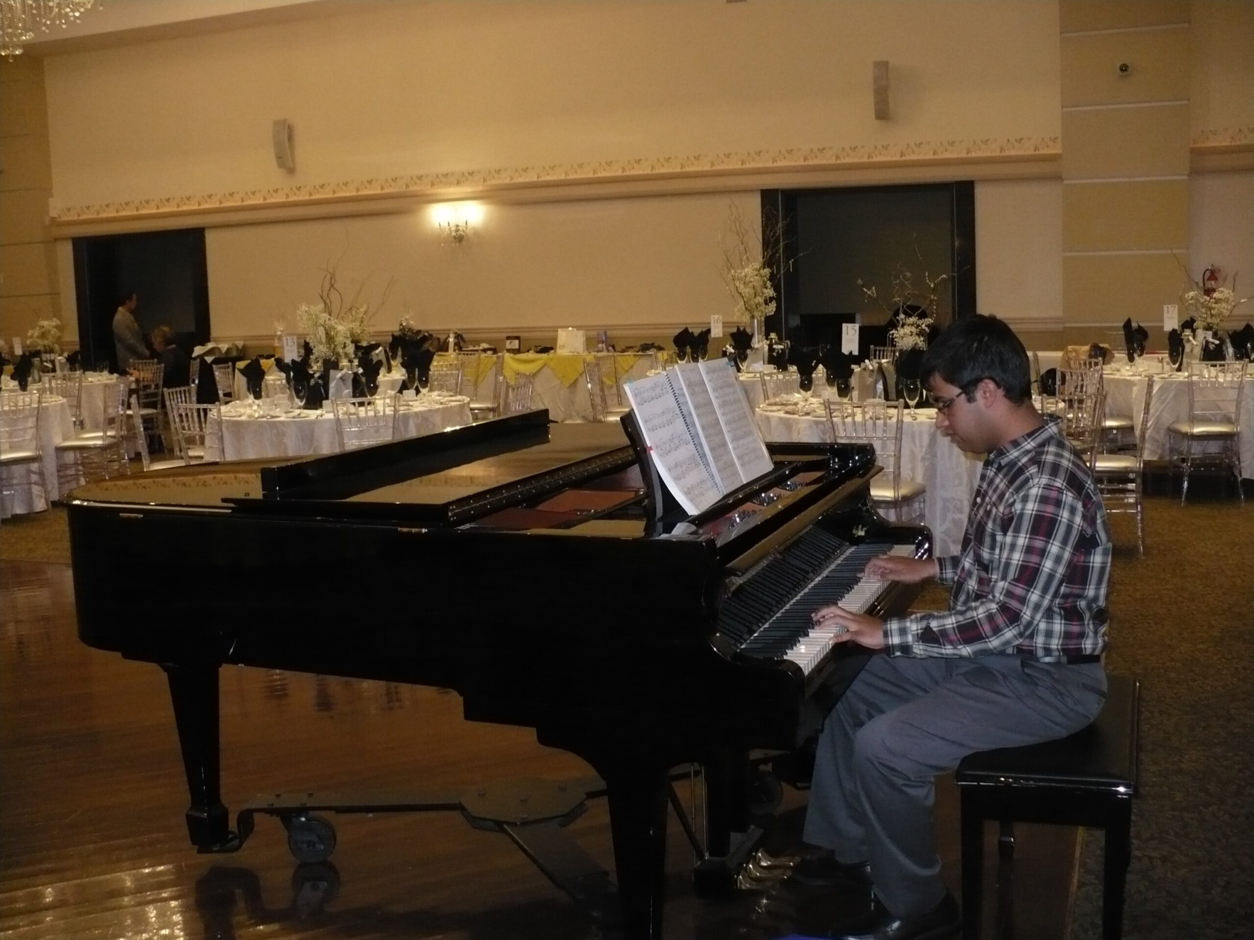 A young boy playing the piano at the 2015 Emajjin Reach for the Stars gala