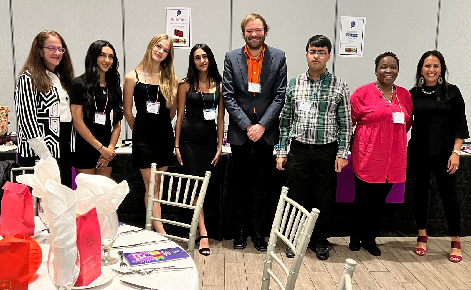 Emajjin's volunteer team of eight people standing together and smiling at the 2022 Celebration gala
