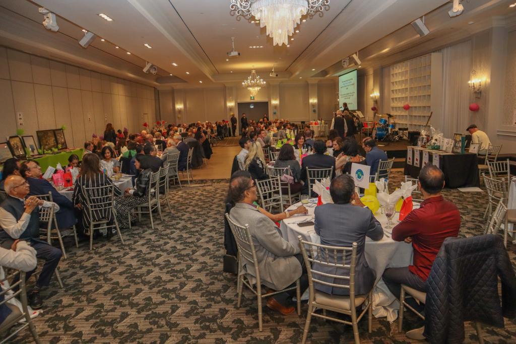 Wide shot of the entire room at the 2022 Celebration gala showing tables, decorations, a central dance floor and projector